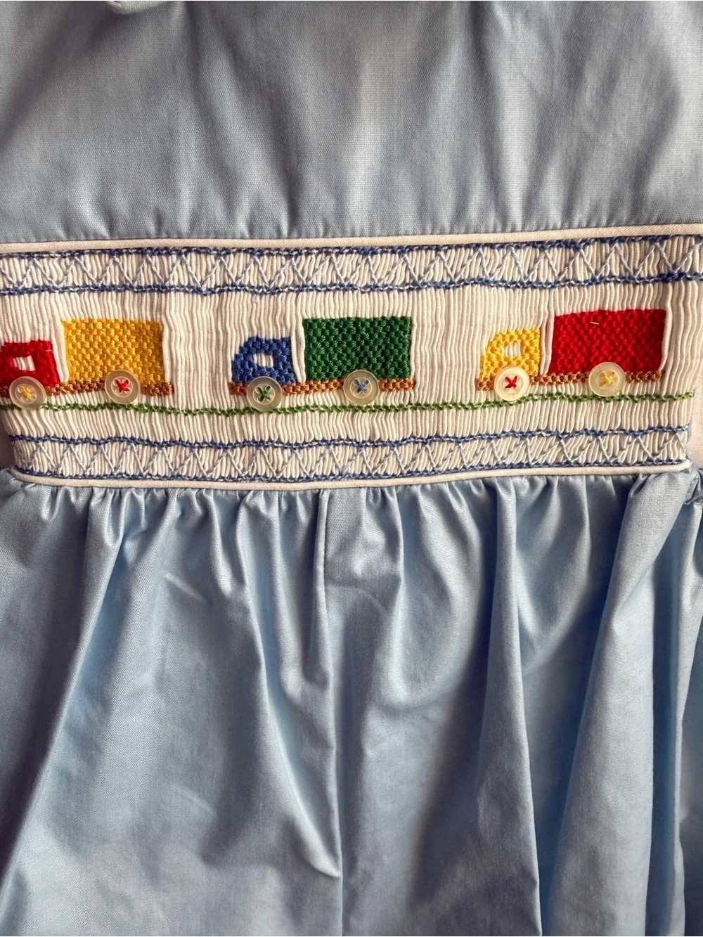 House of Hatten Smocked Blue & White Baby Romper with Colorful Truck Motif